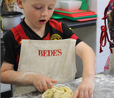 un bambino prepara dolci a Eastbourne college- Bede's Summer School